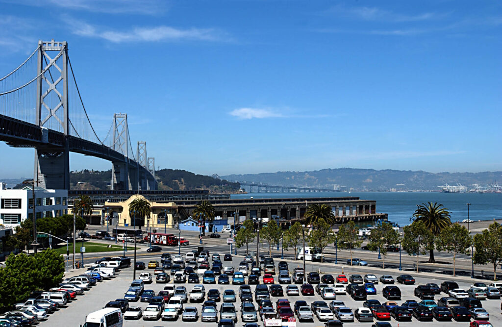 A parking lot and the Bay Bridge near Bayside Village in San Francisco.